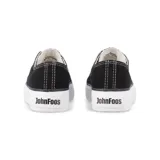 Zapatillas bajas de lona negra con suela de plataforma blanca, cordones blancos y etiqueta con logo en la lengüeta.