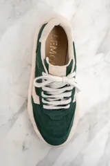 Zapatillas deportivas de gamuza verde con detalles en cuero color crema, cordones blancos y suela chunky color crema.