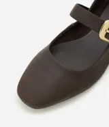 Zapatilla tipo bailarina Satinato de cuero negro, con punta cuadrada, tacón bajo y tira en el empeine con hebilla metálica dorada grande.