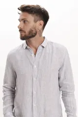 Camisa de lino de manga larga con diseño de rayas verticales finas, cuello clásico y cierre frontal abotonado.