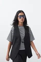 Chaleco sastrero de color marrón, con silueta recta, escote en V y cierre frontal con botones. Presenta una estructura definida y tejido con caída firme.