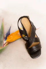 Sandalias color beige con tiras cruzadas y taco cuadrado.