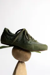 Zapatillas deportivas de caña baja color verde militar, con cordones y suela de goma marrón.