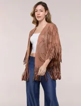 Chaqueta de suede sintético marrón, de corte holgado y frente abierto, con mangas cortas anchas. Presenta diseño de perforaciones láser con motivos circulares y terminación de flecos largos en el ruedo y las mangas.