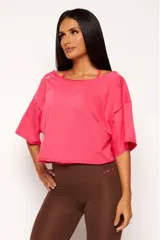 Remera corta de manga corta color celeste, con escote amplio en la espalda que se anuda en la parte inferior, dejando ver un top deportivo amarillo con tiras cruzadas.