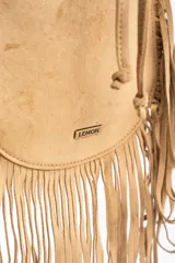 Cartera tipo bucket bag color camel, confeccionada en material sintético con acabado gamuzado. Presenta un diseño decorado con flecos largos en todo el contorno, cierre mediante cordón ajustable y correa larga regulable.