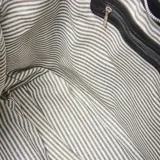 Cartera tipo hobo de cuero negro con diseño amplio, asa única reforzada y herrajes metálicos plateados.