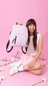 Mochila de nylon color verde oliva, con cierre principal y dos bolsillos frontales con cierre. Tiene correas de hombro ajustables en color negro y asa superior de agarre.