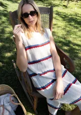 Vestido midi tejido en hilo de algodón, sin mangas y con escote redondo. Presenta un diseño de rayas horizontales en tonos beige, azul y rojo.