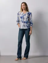 Blusa de gasa estampada con flores azules y blancas, marca Sioni. Tiene escote en V, abertura frontal con botones y mangas 3/4 con puños fruncidos y botón.