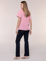 Blusa blanca de textura gofrada, de corte recto y semi holgado, con mangas cortas y escote redondo adornado con un canesú frontal en crochet calado.
