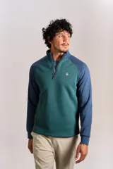 Buzo de cuello alto con cierre frontal parcial, diseño bicolor con cuerpo en verde y mangas raglán en azul. Presenta el logo de la marca bordado en el pecho.