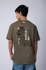 Remera de corte semi-oversize en color naranja con efecto de lavado tipo snow. Presenta un pequeño estampado gráfico en el pecho y cuello redondo.