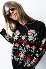 Buzo tejido de algodón negro con diseño jacquard de flores multicolor, cuello en V y mangas largas.
