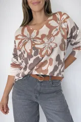 Tejido fino de media estación con estampado floral tipo print en tonos beige y marrón, con aplicaciones de strass que forman tréboles y la palabra "LOVE". Presenta cuello en V y manga larga.