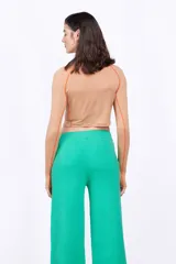 Top deportivo ajustado color morado oscuro, de manga larga con orificios para los pulgares y cuello alto. Presenta costuras en contraste gris claro y un pequeño logo bordado en el pecho.