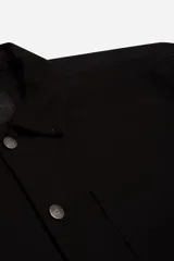 Sobrecamisa de tejido twill de algodón en color beige, con estructura firme, cuello clásico, cierre frontal con botones metálicos y bolsillo aplicado en el pecho.