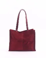Bolso tipo shopper de gran tamaño, confeccionado en cuero gamuzado color marrón. Presenta estructura rectangular con bordes reforzados en cuero liso oscuro, doble asa de hombro y cierre mediante botón magnético.