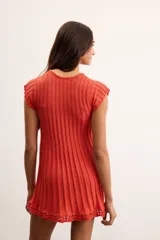 Vestido corto de punto acanalado color naranja, de manga corta y cuello redondo, con detalle de terminación en crochet en el ruedo.