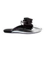 Sandalia mule plateada con moño negro de satén.