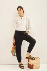 Pantalon tipo cargo color negro, de corte holgado, con bolsillos laterales y en las piernas. Posee cierre y botones en el frente, cintura elástica y puños elásticos en el ruedo.