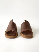 Sandalias marrones de cuero texturizado con diseño de tira ancha en el empeine y separación para el dedo, taco cuadrado bajo y suela plataforma.
