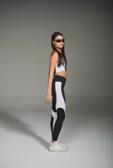 Calza deportiva larga negra con recortes laterales blancos.