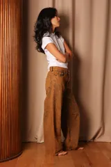 Pantalón de jean color marrón con efecto desgastado, corte amplio y tiro alto.