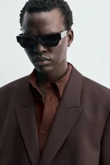 Blazer de traje cruzada de corte regular fit, color marrón oscuro, con solapas de muesca, bolsillos de doble vivo en la cadera y cierre frontal de botonadura doble.
