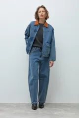 Jean de corte barrel con costuras horizontales en las rodillas, confeccionado en denim azul de lavado medio.