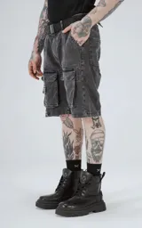 Bermuda de denim color negro con efecto acid wash y múltiples bolsillos cargo. Presenta un calce oversize y costuras marcadas.