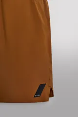 Pantalón corto deportivo color marrón oliva, confeccionado en tejido técnico ligero y elástico, con forro interior. Presenta cintura elástica ajustable con cordón, bolsillos frontales, bolsillo de seguridad trasero con cierre y aberturas laterales en el bajo.