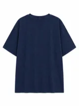 Remera de algodón con efecto lavado, color negro, de corte holgado y manga corta. Presenta un estampado gráfico central con tipografía y elementos abstractos en tonos claros.