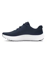 Championes de running Under Armour modelo Charged Surge 4, color azul marino con entresuela blanca. Presentan parte superior de malla transpirable con superposiciones sintéticas, amortiguación Charged Cushioning y suela de goma resistente.