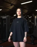 Remera negra de algodón, corte oversize, con inscripción 'GAINS.' en el frente.
