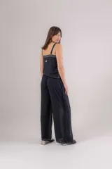 Pantalón de viscosa azul marino con cruce en las piernas tipo pareo, generando tajos laterales. Presenta bordados blancos en los bordes.