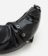 Cartera tipo shoulder bag de diseño media luna, confeccionada en poliuretano con acabado brillante. Presenta detalles frontales estilo gota, cierre superior por cremallera y correa de hombro ajustable con ojetes metálicos.