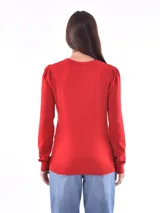 Sweater rojo de tejido de punto liso, con cuello redondo y mangas largas con leve frunce en los hombros.