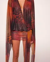 Minivestido cruzado con estampado animal print en tonos naranja, marrón y negro. Tiene escote en V pronunciado, mangas largas acampanadas y falda ajustada.