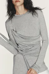 Vestido midi de cuello redondo y manga larga, con la parte superior gris y la falda blanca. La parte superior presenta un detalle de tejido superpuesto ajustable con lazada en la cintura. La falda es de tipo gabardina.