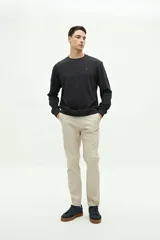 Buzo de felpa gris oscuro, con textura de tejido waffle o gofrado. Presenta cuello redondo, manga larga y un pequeño logo bordado en el pecho.