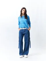 Mochila pequeña color rosa pálido con correas ajustables y asa superior. Tiene un bolsillo frontal con cierre y un parche con el logo de la marca en la parte inferior.