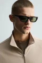 Sudadera de algodón color beige claro con efecto lavado, corte relajado, cuello alto y cierre frontal de cremallera. Presenta bolsillos de vivo en la cadera y mangas largas.