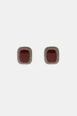 Aros de diseño cuadrado con centro de resina color bordó con vetas oscuras, rodeado por un marco de pequeños cristales brillantes. Cierre con tuerca.