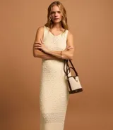 Vestido midi color crema, tejido en punto texturizado, sin mangas y con cuello redondo.
