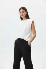 Remera de algodón color blanco con cuello redondo y hombreras marcadas, de corte holgado y sin mangas.