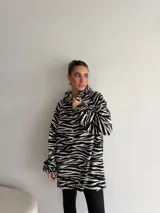 Canguro de viscosa con capucha, mangas largas abullonadas y diseño oversize con estampado animal print tipo cebra en tonos marrón y negro.