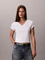 Remera de Calvin Klein Essentials confeccionada en punto de algodón elástico con textura de canalé. Presenta un diseño de corte slim, cuello en V, manga corta y una pequeña insignia con el logo de la marca en el bajo.