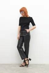 Pantalón de cuero sintético negro, de corte recto y tiro medio.