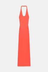 Vestido largo color salmón con cuello halter, escote redondo y espalda descubierta. Cuenta con bajo acabado asimétrico, cierre en el cuello con botón y cremallera oculta en la espalda.